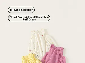 Detail of girls' embroidered bubble dresses in cream, purple and yellow cotton fabric