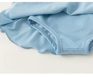 Gros plan détaillé sur les doubles coutures renforcées de l'ourlet du maillot bleu clair