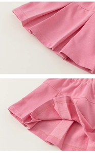 Dettaglio della gonna a pieghe rosa in maglia con trama in tessuto French Terry densa