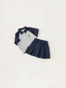 Completo bambina con polo a contrasto e gonna a pieghe blu navy con ricamo orso