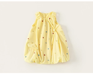 Detail of light yellow sleeveless flower girl dress with delicate floral embroidery and pleats