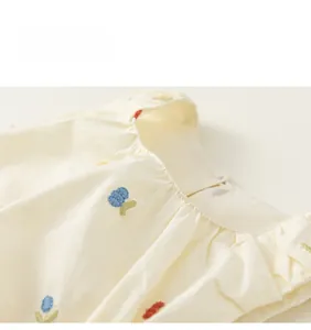 Detailed view of the neckline featuring floral embroidery and gathered fabric on the dress