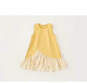 Dettaglio di abito estivo per bambina con corpino giallo e balze color crema