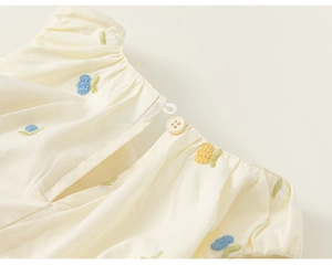 Detailed view of the child dress featuring cotton fabric and delicate floral embroidery