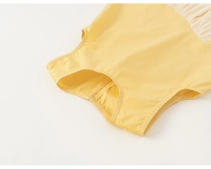 Dettaglio della scollatura dell'abito in cotone giallo con cuciture lisce e bordi