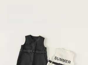 Detail view of boys utility rompers in charcoal and cream featuring a summer back print