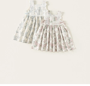 Close-up of floral summer dresses with delicate lace trim and ribbon bows for girls