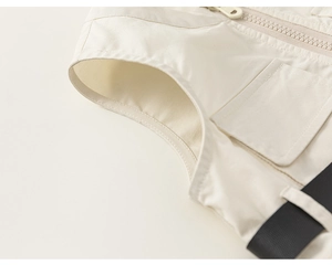 Detail view of cream toddler romper showing the sturdy zipper and utility pocket design