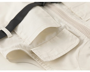 Detail of off-white cargo canvas romper with 3D pockets and black nylon webbing straps