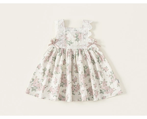 Close-up of girls floral sleeveless dress with lace stitching and purple bow details