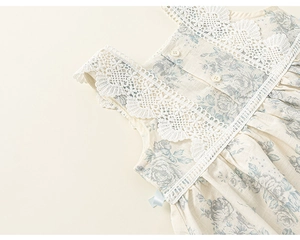 Detail of floral baby dress with white lace collar and delicate rose patterns