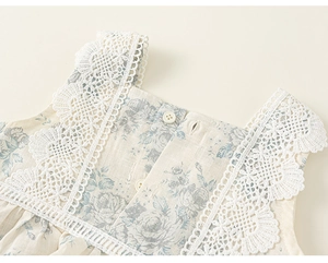 Detailed view of girl's floral dress neckline with lace trim and retro rose pattern