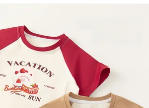 Detail of raglan sleeves and cartoon strawberry cake print on kids beige cotton T-shirt