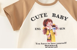 Detailed close-up of cartoon print and raglan sleeves on girls' cotton summer T-shirt