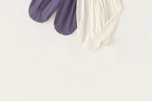 Detailed close-up of girls' cotton linen split hem trousers in purple and cream white