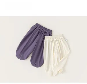Detail of loose-fit cotton linen kids pants with split hems in purple and beige