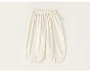 Detail of loose beige toddler pants with elastic waist and side split leg opening