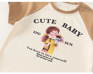 Close-up of raglan sleeve kids' T-shirt featuring a cute cartoon girl graphic print