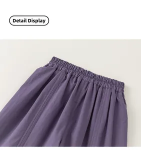 Detail of elastic gathered waistband on girls' light purple cotton summer trousers