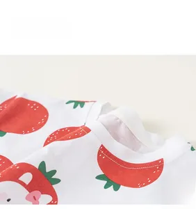 Dettaglio della maglietta in cotone per bambina con stampe di fragole e fiocchi rosa