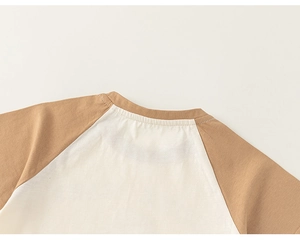 Close-up of crew neck stitching and raglan sleeves on a cotton t-shirt for girls