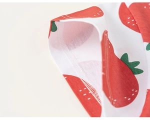Dettaglio del tessuto in cotone con stampa fragola e rifinitura con cucitura a doppio ago