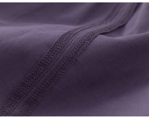 Detailed macro view of high-quality overlock stitching on purple textile fabric pants