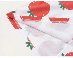 Dettaglio ravvicinato delle cuciture dell'orlo su una t-shirt bianca in cotone con fragole