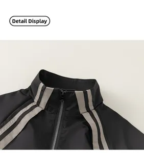 Detail view of the boys' jacket stand collar with parallel grey stripes and metal zipper