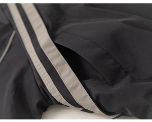 Close-up of black boys jacket showing waterproof fabric and grey side stripes detail