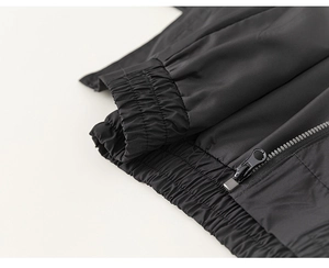 Close-up of black boys' jacket showing zipper detail and elastic cuffs with fine texture