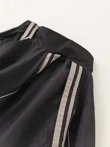 Close-up of boys black athletic sports jacket with side stripes and stand collar