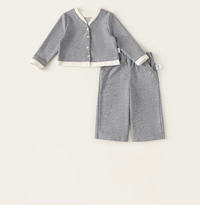 Detail view of children knit grey cardigan and trousers set with white piping