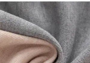 Close-up of dual-layer knitted fabric with soft gray outer and beige fleece lining