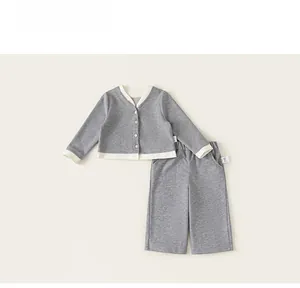 Detail view of children's grey knit cardigan set with white contrast trim and V-neckline