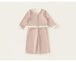 Detail of baby girl knit cardigan and pants set with contrast trim and button closure