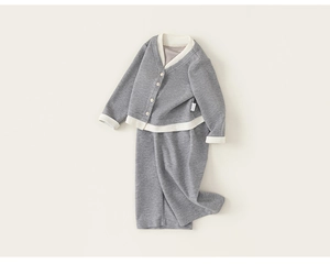 Close-up detail of grey kids knit cardigan set with white V-neck trim and soft fabric