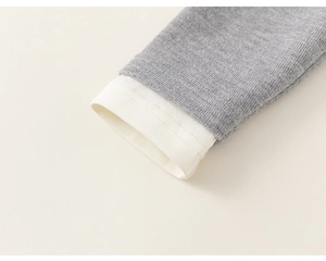 Detailed close-up of grey marl knit sleeves with white ribbed elastic cuffs