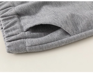 Detail of grey cotton blend sports trousers showing elastic waistband and side pocket stitching
