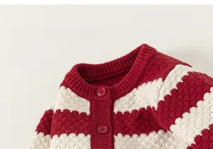 Detailed close-up of red and white striped knit cardigan with heart embroidery