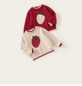Detail of red and beige girls' sweaters with strawberry patches and wavy ribbed hems