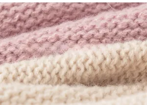 Close-up of pink and cream chunky knit fabric showing soft texture and detailed stitching