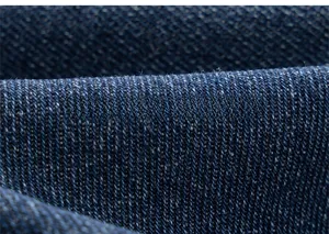 Gros plan sur la texture du tissu denim bleu foncé montrant les détails du tissage sergé