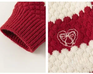 Detail of red and white knit cardigan showing ribbed cuffs and heart bow embroidery