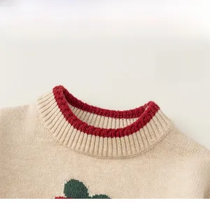 Detail of baby knit sweater featuring a colorful ribbed crew neck and polka dot pattern