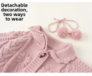 Detail view of pink cable knit cardigan with floral embroidery and wooden horn buttons