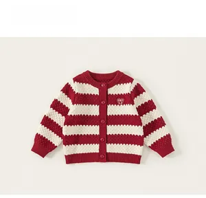 Detail of red and white striped knit cardigan featuring heart embroidery and buttons