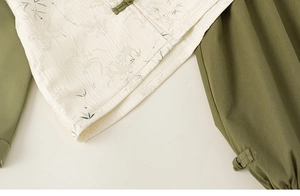 Detail of bamboo jacquard fabric and traditional green knot button on white top