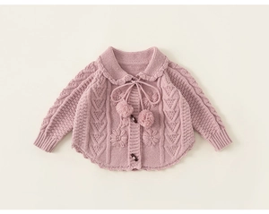 Detail of girls knit cardigan with floral embroidery, cable texture and horn buttons