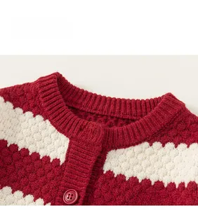 Detail of red and white knit cardigan showing 3D ball texture and embroidered heart